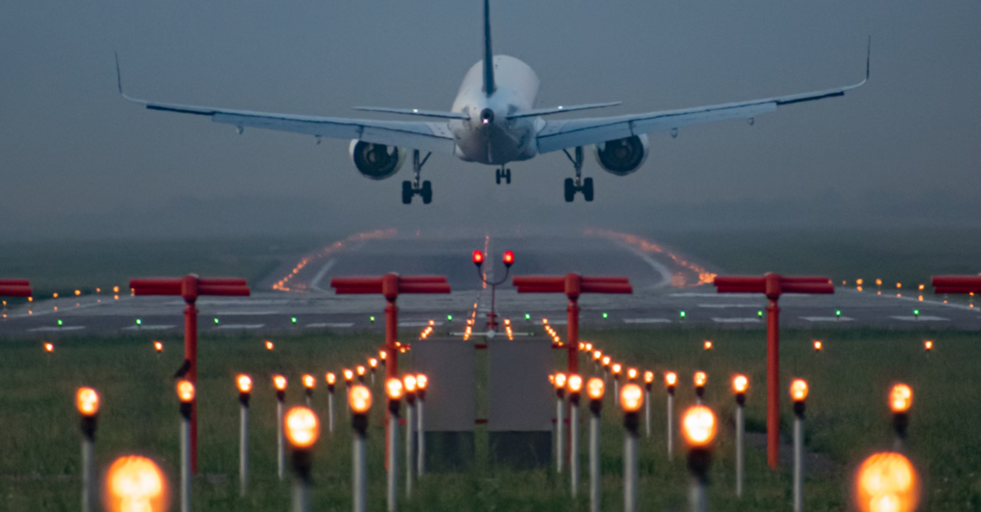 Commercial airliner on final approach over illuminated runway guidance lights
