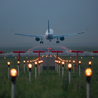 Commercial airliner on final approach over illuminated runway guidance lights
