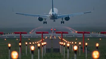 Commercial airliner on final approach over illuminated runway guidance lights