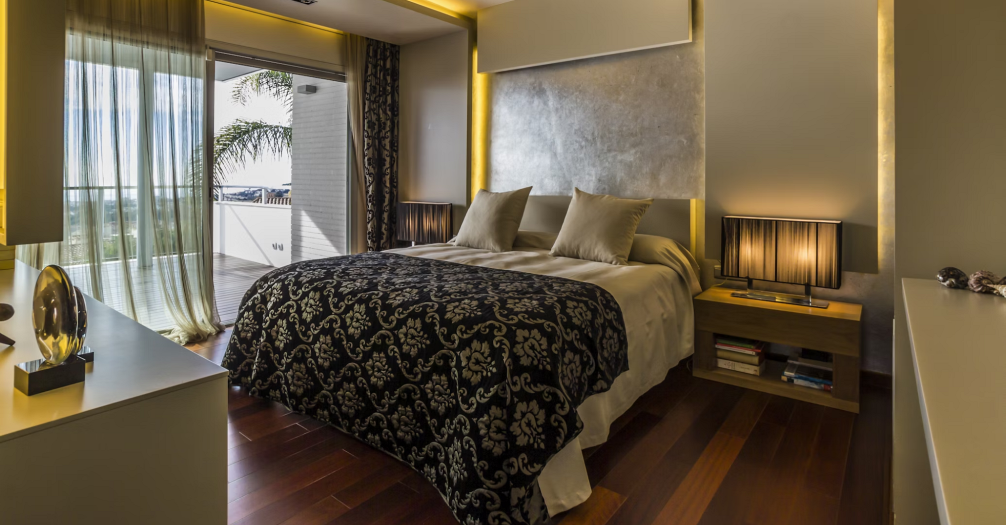 Modern hotel room with large bed and warm lighting