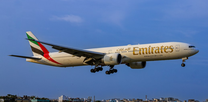 Emirates aircraft approaching landing with cityscape below