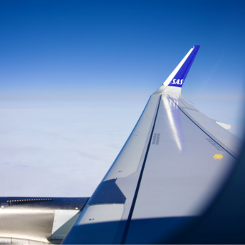 View of an SAS aircraft wing during flight above the clouds
