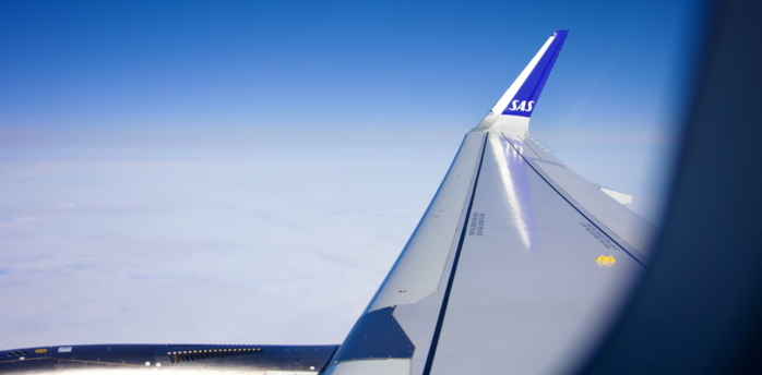 View of an SAS aircraft wing during flight above the clouds