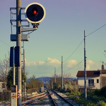 Railway signal showing red light on quiet train tracks near Verona