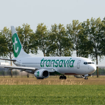 Transavia aircraft on runway with trees in background