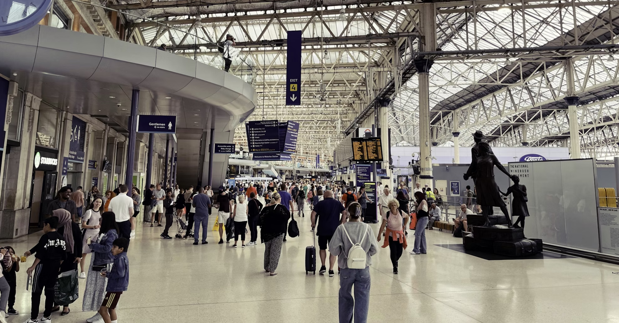 Crowded transit hub with travellers and departure boards