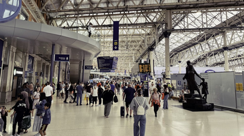 Crowded transit hub with travellers and departure boards