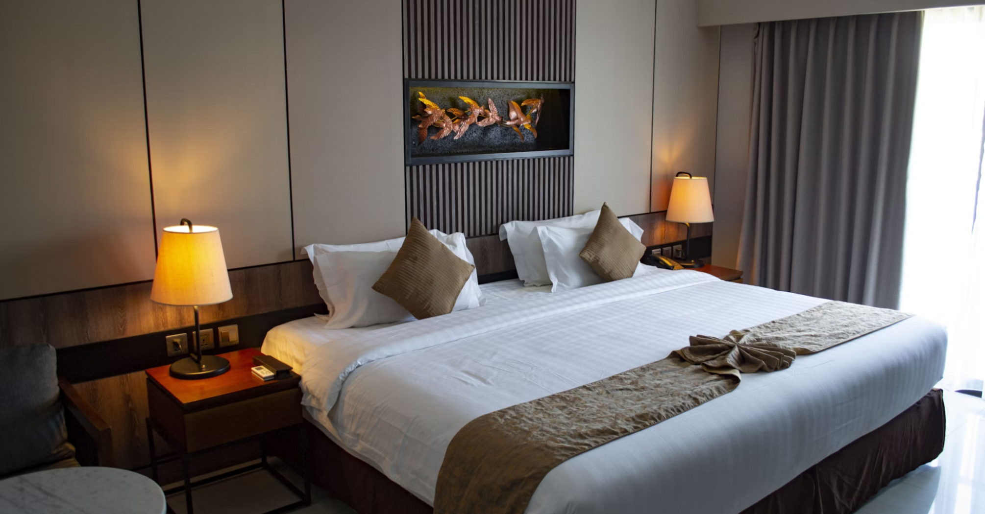 Renovated hotel room with king-size bed and modern lighting
