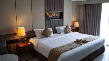 Renovated hotel room with king-size bed and modern lighting