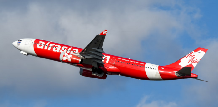 AirAsia aircraft in flight against a cloudy sky