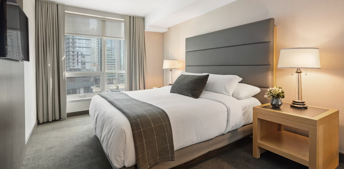Modern hotel room with large bed and city view