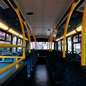 Empty interior of a public bus with yellow poles and blue seats