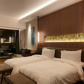 Modern hotel room with two twin beds and warm lighting