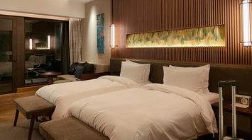 Modern hotel room with two twin beds and warm lighting