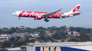 AirAsia aircraft in flight against a blue sky