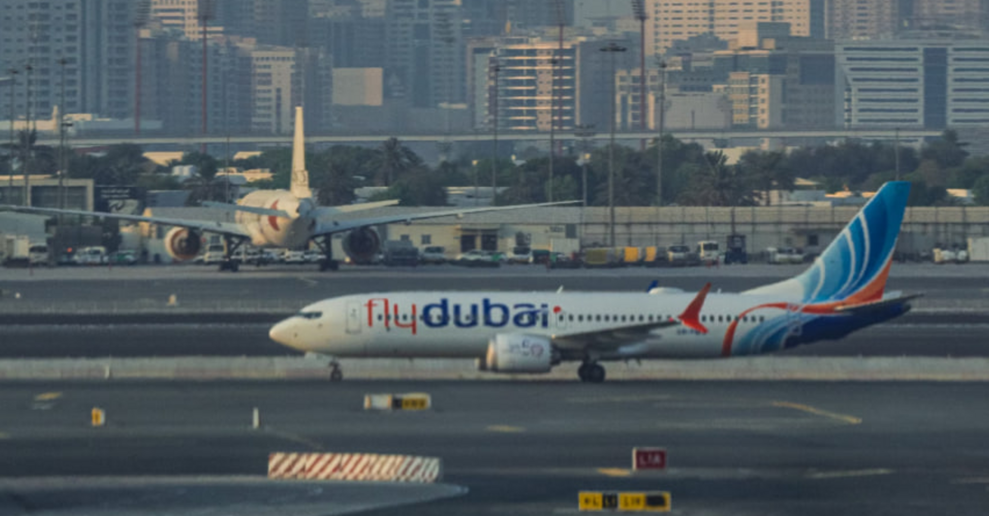flydubai aircraft on the runway with city skyscrapers in the background