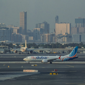 flydubai aircraft on the runway with city skyscrapers in the background