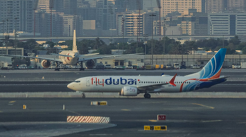 flydubai aircraft on the runway with city skyscrapers in the background