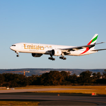 Emirates aircraft landing on a runway during daylight