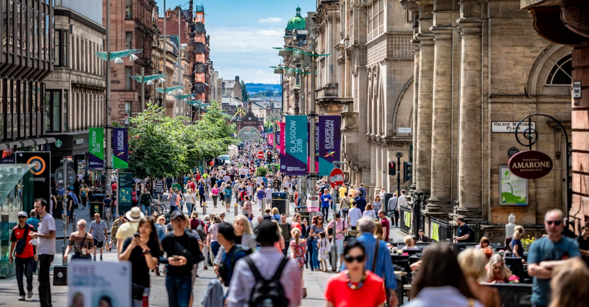 Crowds walking along Buchanan Street in central Glasgow on a sunny day