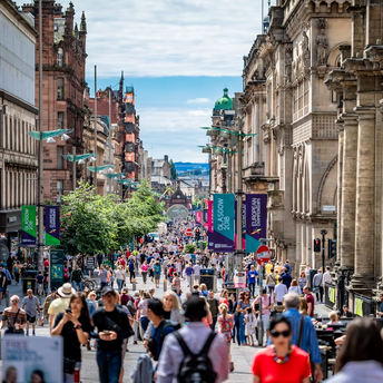 Crowds walking along Buchanan Street in central Glasgow on a sunny day