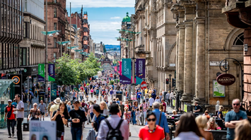 Crowds walking along Buchanan Street in central Glasgow on a sunny day
