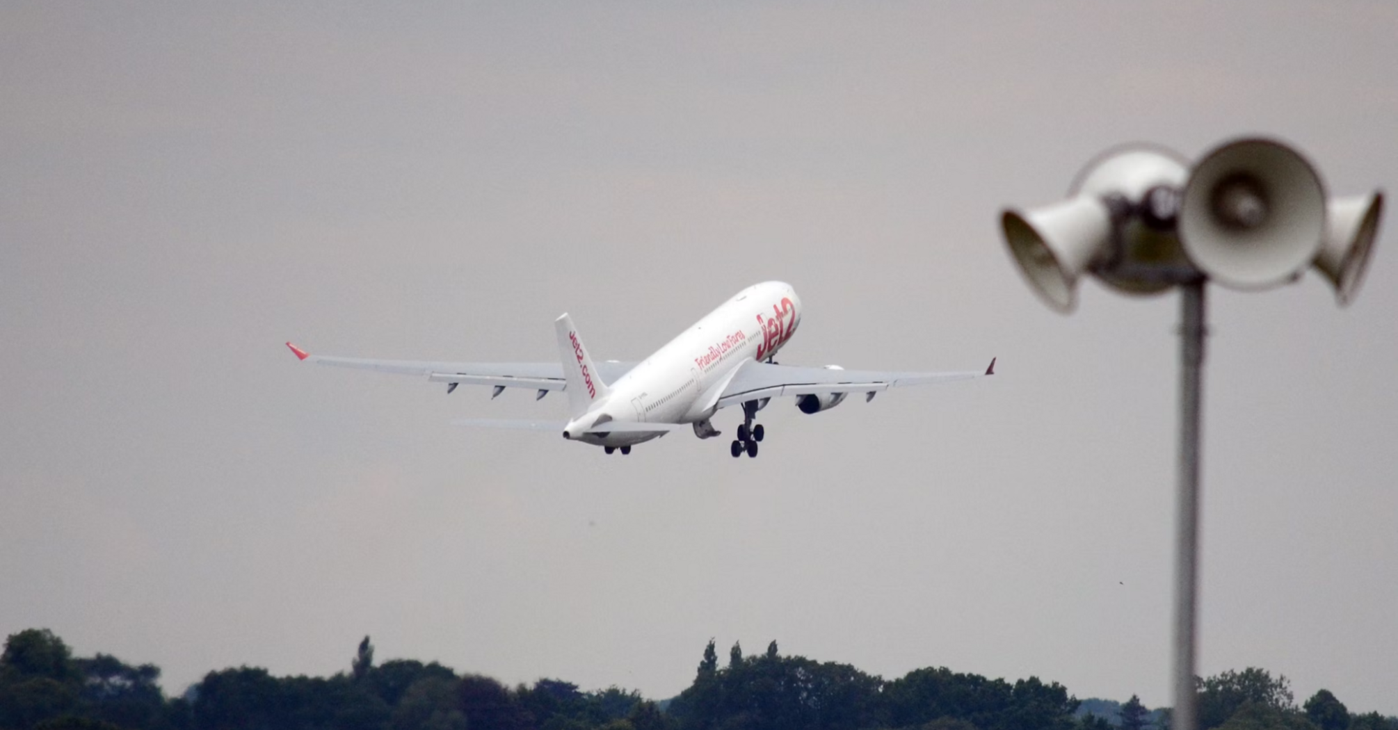 Airplane taking off from a runway with forest in the background