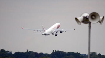 Airplane taking off from a runway with forest in the background
