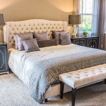 Interior of a modern bedroom with neutral tones and decorative pillows