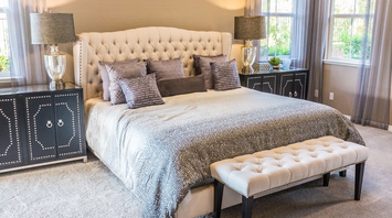 Interior of a modern bedroom with neutral tones and decorative pillows