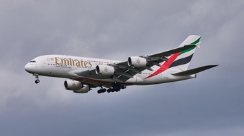 Emirates Airbus A380 flying against a cloudy sky