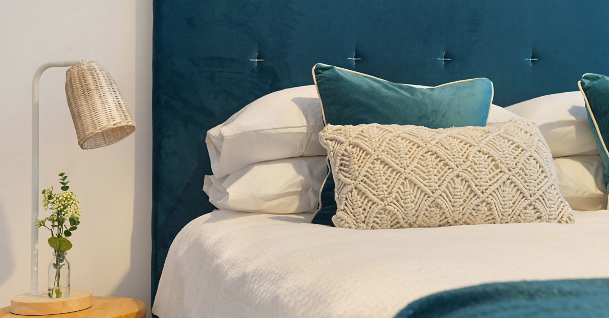 Stylish hotel bed with textured pillows and modern lighting