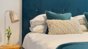 Stylish hotel bed with textured pillows and modern lighting