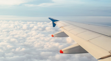 Air Corsica aircraft wing above the clouds during flight