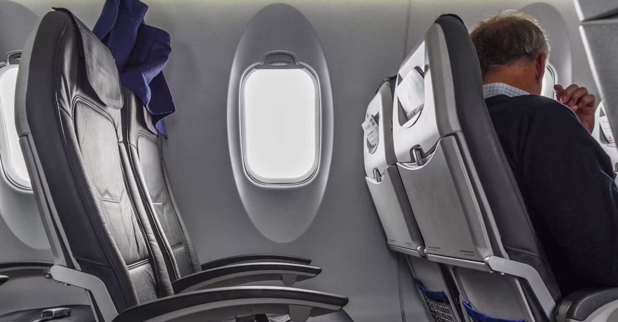 Empty and occupied seats inside a commercial airplane cabin