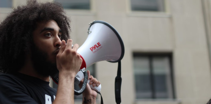 Person speaking into a megaphone during a public demonstration