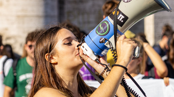Young woman speaking into a megaphone at a protest