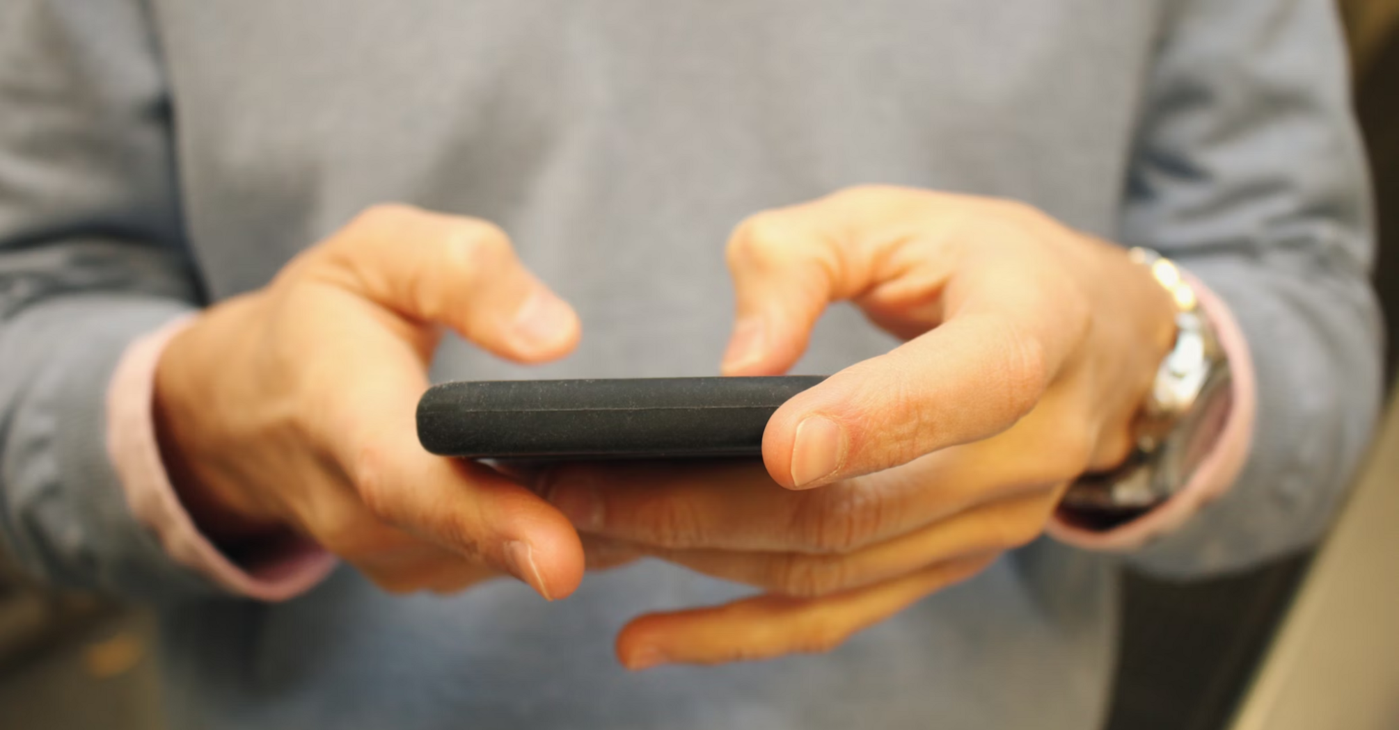 Person holding a smartphone and typing