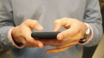 Person holding a smartphone and typing