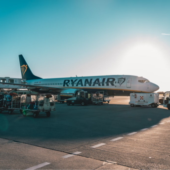 Ryanair aircraft on airport tarmac during ground handling at sunset