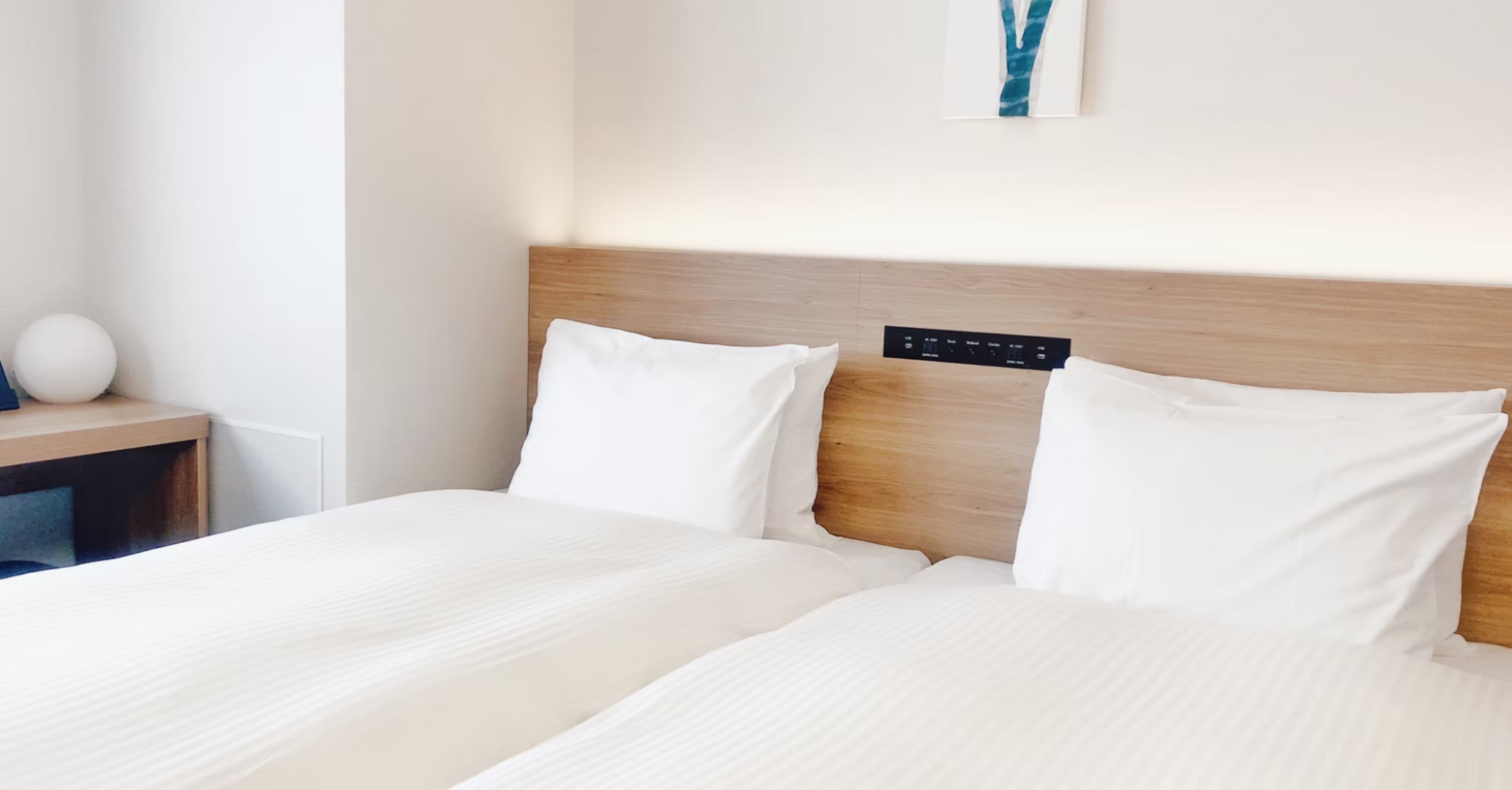 Bright modern hotel room with two neatly made twin beds and minimalist decor