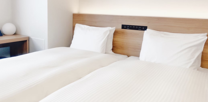 Bright modern hotel room with two neatly made twin beds and minimalist decor