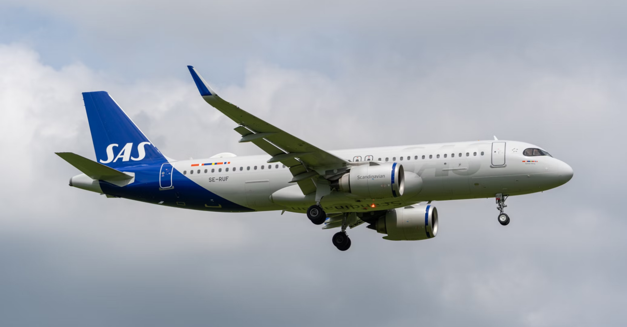 SAS Airbus A320neo regional jet in flight under cloudy sky