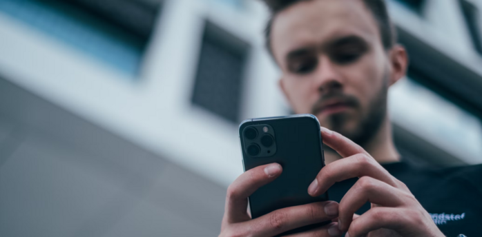 Man checking updates on a smartphone outdoors