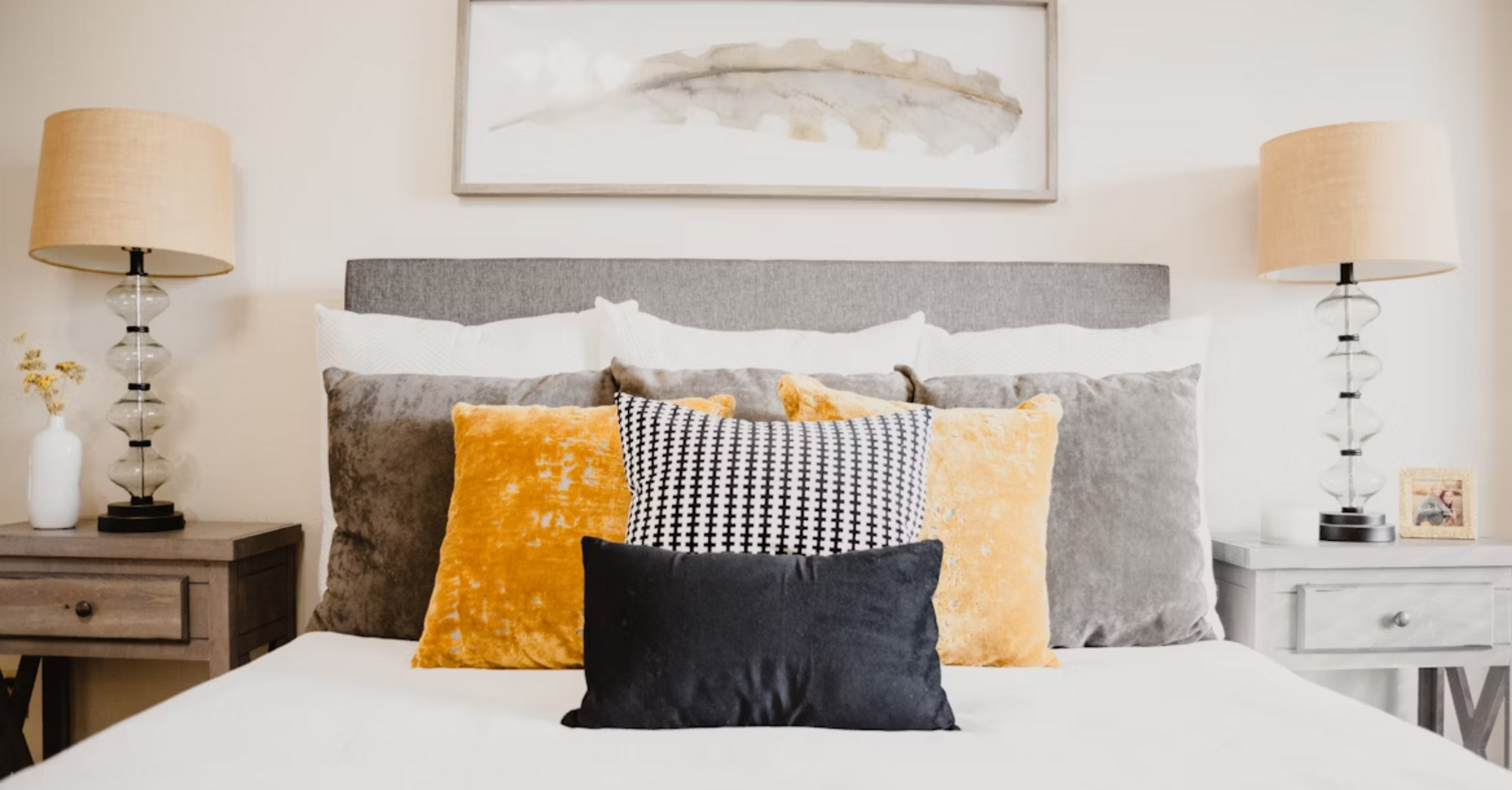 Stylish bed with decorative pillows and modern lighting in a villa bedroom