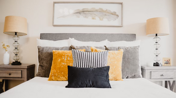 Stylish bed with decorative pillows and modern lighting in a villa bedroom