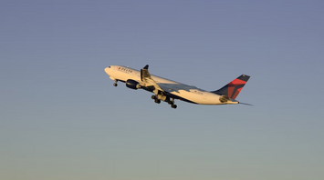 Delta Airlines Boeing 767 aircraft climbing after takeoff at sunset