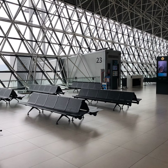 Empty airport gate seating area with modern glass structure