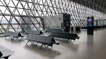 Empty airport gate seating area with modern glass structure