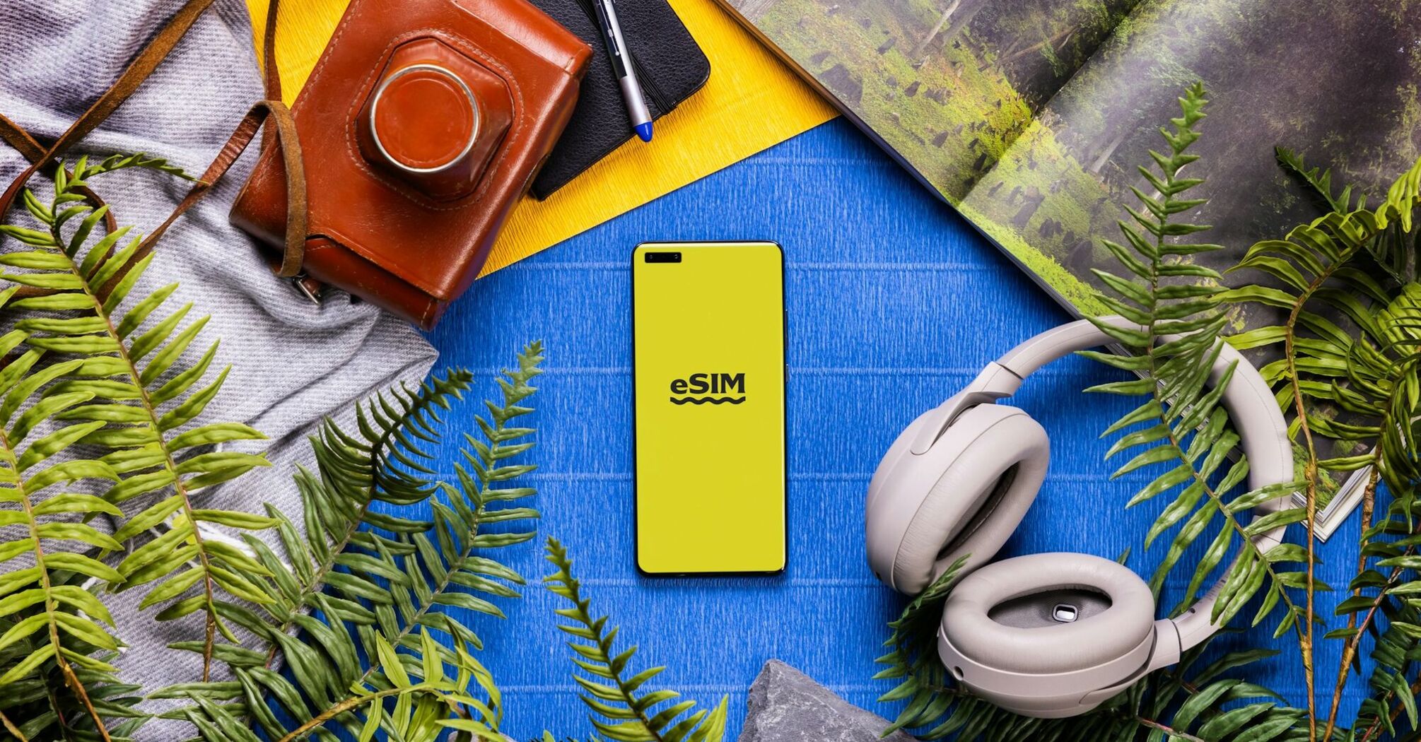 Smartphone with eSIM screen surrounded by travel accessories